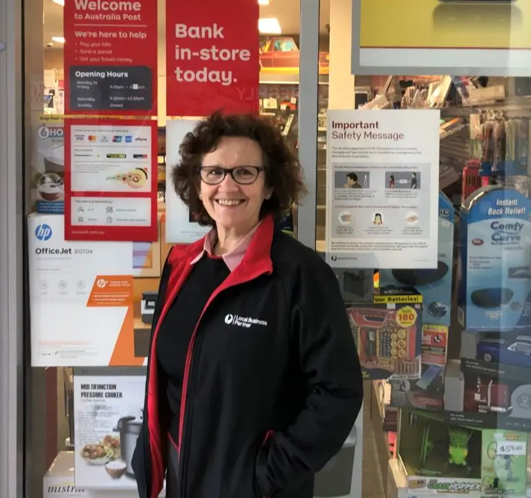 Australia Post worker standing outside local post office